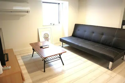 a living room with a black couch and a table at Shibuya-ku - Apartment / Vacation STAY 1103 in Tokyo