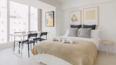 a white bedroom with a bed and a table and chairs at Hotel Apartment Ueno Inaricho Sta in Tokyo