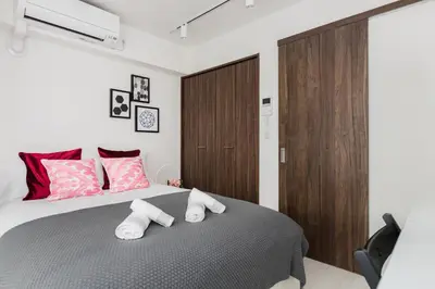 a bedroom with a large bed with two pillows at Hotel Apartment Ueno Inaricho Sta in Tokyo