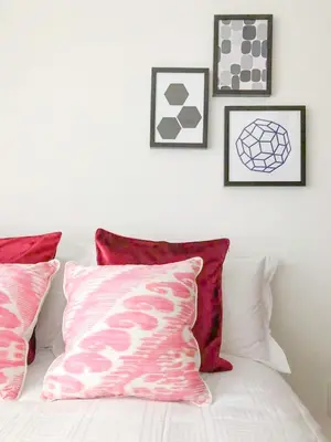 a white bed with pillows and pictures on the wall at Hotel Apartment Ueno Inaricho Sta in Tokyo