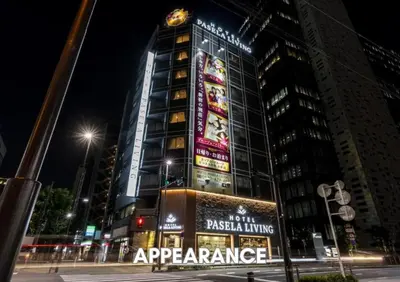 a tall building with a sign on it at night at Hotel Pasela Living Shinjuku in Tokyo
