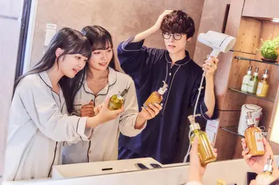 two girls and a boy standing in front of a mirror at Hotel Pasela Living Shinjuku in Tokyo