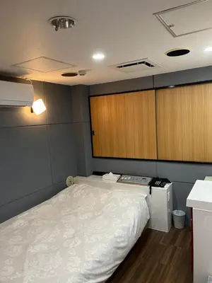 a small room with a bed and a cabinet at City Hotel Southern Cross in Tokyo