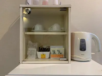 a cupboard filled with dishes and a coffee maker at City Hotel Southern Cross in Tokyo