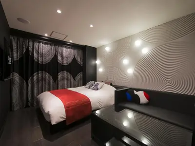 a bedroom with a bed and a couch at Hotel Crest Hirai (Adult Only) in Tokyo
