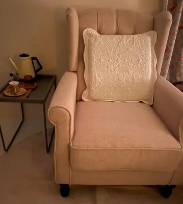 a chair with a pillow next to a side table at minimalist\u7d4c\u5802\u306e\u5c0f\u3055\u306a\u304a\u90e8\u5c4b in Tokyo