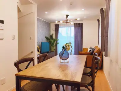 a dining room table and chairs in a living room at Etranger Kaname Cho in Tokyo