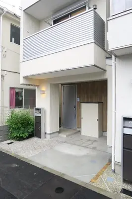 a white building with a door in front of it at Etranger Kaname Cho in Tokyo