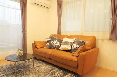 a living room with a couch with pillows on it at Etranger Kaname Cho in Tokyo
