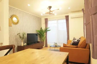 a living room with a couch and a television at Etranger Kaname Cho in Tokyo
