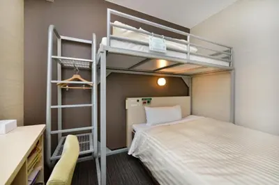 a bedroom with a bunk bed and a desk and a bed at Super Hotel Tokyo JR Shinkoiwa in Tokyo