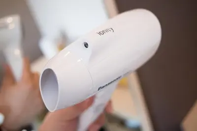 a person holding a white hair dryer in their hand at Super Hotel Tokyo JR Shinkoiwa in Tokyo