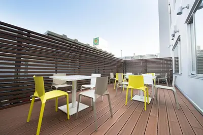 a cafeteria with tables and yellow chairs on a balcony at Super Hotel Tokyo JR Shinkoiwa in Tokyo