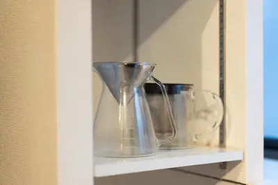 a row of glass vases sitting on a shelf at SATELLITE HOTEL Yoyogi Sangubashi \u30b5\u30c6\u30e9\u30a4\u30c8\u30db\u30c6\u30eb\u4ee3\u3005\u6728\u53c2\u5bae\u6a4b in Tokyo