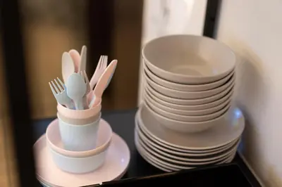 a stack of plates and chopsticks and forks in cups at SATELLITE HOTEL Yoyogi Sangubashi \u30b5\u30c6\u30e9\u30a4\u30c8\u30db\u30c6\u30eb\u4ee3\u3005\u6728\u53c2\u5bae\u6a4b in Tokyo