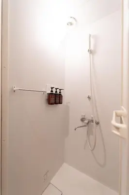 a white bathroom with a shower with a glass door at SATELLITE HOTEL Yoyogi Sangubashi \u30b5\u30c6\u30e9\u30a4\u30c8\u30db\u30c6\u30eb\u4ee3\u3005\u6728\u53c2\u5bae\u6a4b in Tokyo