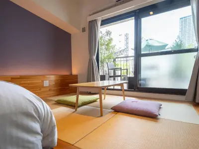 a living room with a table and a large window at Hotel Tokyo Trip Ueno Nishi Nippori in Tokyo