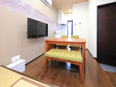 a room with a table with two chairs and a television at COTO Tokyo Nakano in Tokyo