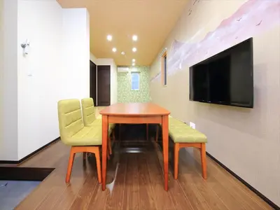 a dining room with a table and two chairs and a television at COTO Tokyo Nakano in Tokyo