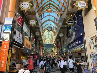 a group of people walking through a shopping mall at COTO Tokyo Nakano in Tokyo