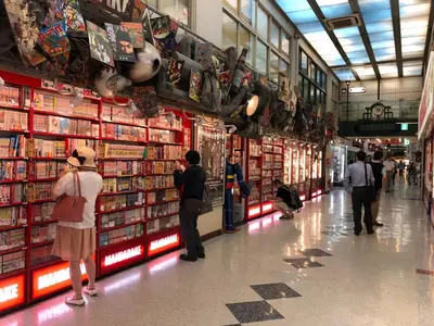 a group of people standing in a store aisle at COTO Tokyo Nakano in Tokyo
