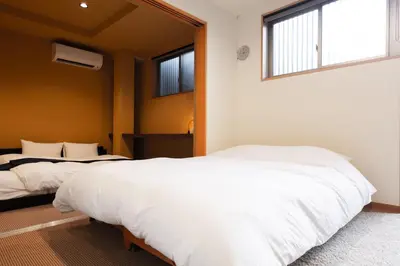 a bedroom with two beds and a window at \u5bbf\u574a \u6b63\u4f1d\u5bfa Temple hotel Shoden-ji in Tokyo