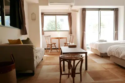a bedroom with a bed and a couch and a table at Tokyo Sakurako Hatchobori in Tokyo