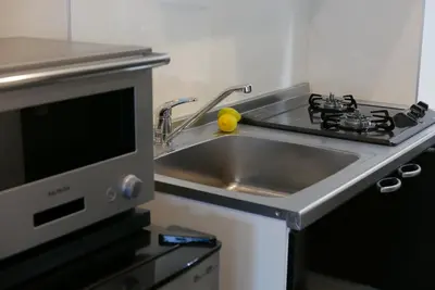 a kitchen with a sink and a microwave at Tokyo Sakurako Hatchobori in Tokyo