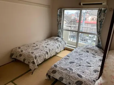 a bedroom with two beds and a window at Tokyo Stay House Otsuka --Kitchen-Living-dining-3room-- in Tokyo