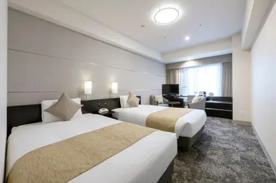 a hotel room with two beds and a desk at Villa Fontaine Grand Tokyo Shiodome in Tokyo