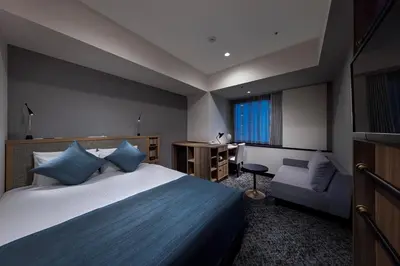 a hotel room with a bed and a chair at Villa Fontaine Grand Tokyo Shiodome in Tokyo