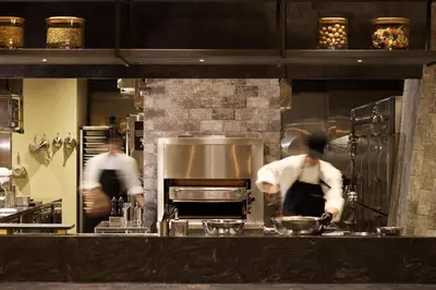 two men in a kitchen preparing food in a kitchen at Villa Fontaine Grand Tokyo Shiodome in Tokyo