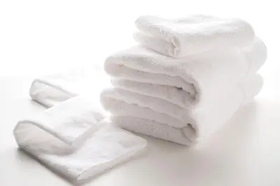 a stack of white towels on a white background at Villa Fontaine Tokyo Kudanshita in Tokyo