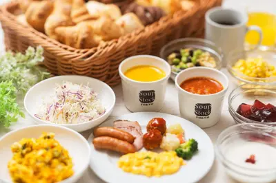 a table with plates of food and bowls of food at Villa Fontaine Tokyo Hamamatsucho in Tokyo