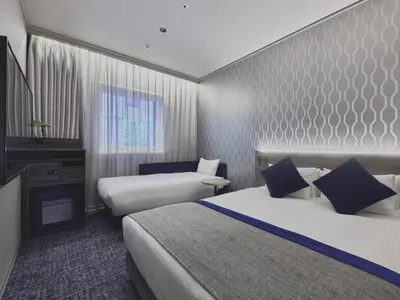 a hotel room with two beds and a television at Villa Fontaine Grand Tokyo Roppongi in Tokyo