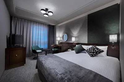 a hotel room with a large bed and a television at Villa Fontaine Grand Tokyo Roppongi in Tokyo