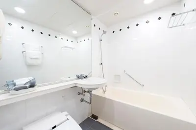 a white bathroom with a sink and a toilet at Villa Fontaine Grand Tokyo Tamachi in Tokyo
