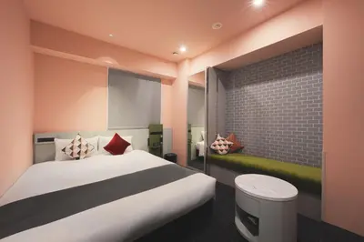 a bedroom with a large bed and a brick wall at Villa Fontaine Tokyo Shinjuku in Tokyo