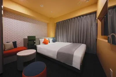 a hotel room with a bed and a chair at Villa Fontaine Tokyo Shinjuku in Tokyo