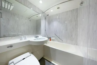 a bathroom with a sink and a toilet and a tub at Villa Fontaine Tokyo Shinjuku in Tokyo