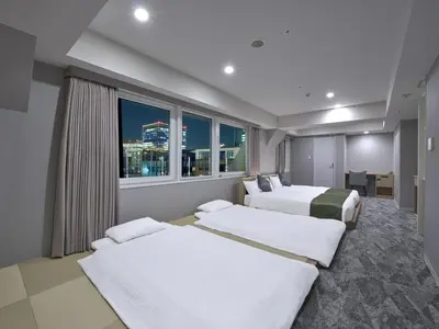 a hotel room with two beds and a window at Villa Fontaine Tokyo Otemachi in Tokyo