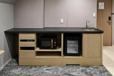 a kitchen with a counter with a microwave and a sink at Villa Fontaine Tokyo Otemachi in Tokyo