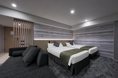 a hotel room with two beds and a couch at Villa Fontaine Tokyo Otemachi in Tokyo