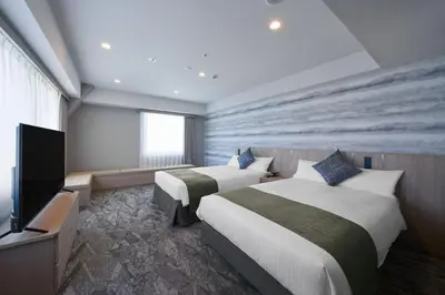 a hotel room with two beds and a flat screen tv at Villa Fontaine Tokyo Otemachi in Tokyo