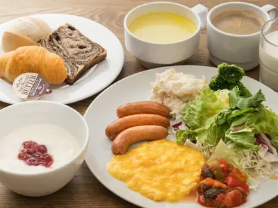 two plates of breakfast food with eggs sausage and bread at Villa Fontaine Tokyo Ueno Okachimachi in Tokyo