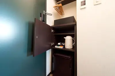 a small kitchen with a black refrigerator in a room at Villa Fontaine Tokyo Ueno Okachimachi in Tokyo