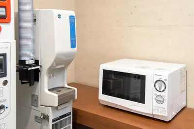 a microwave oven sitting next to a machine at Villa Fontaine Tokyo Ueno Okachimachi in Tokyo