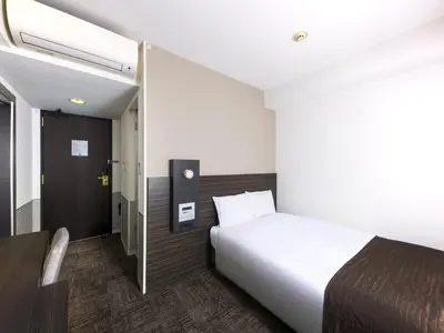 a hotel room with a bed and a door at Villa Fontaine Tokyo Nihombashi Mitsukoshimae in Tokyo