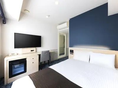 a hotel room with a bed and a flat screen tv at Villa Fontaine Tokyo Nihombashi Mitsukoshimae in Tokyo