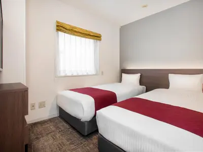 a hotel room with two beds and a window at Villa Fontaine Tokyo Nihombashi Mitsukoshimae in Tokyo